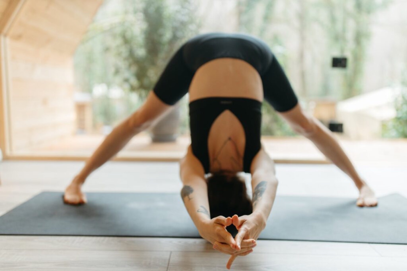 woman in black sports bra and black shorts doing yoga